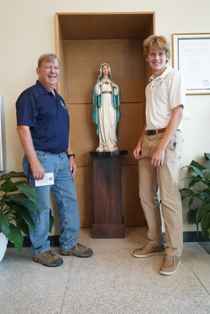Helias Catholic High School graduate Jim Wisch and his grandson, Max Borgmeyer, a sophomore at the school, stand next to the pedestal they built for the new statue of the Immaculate Heart of Mary.